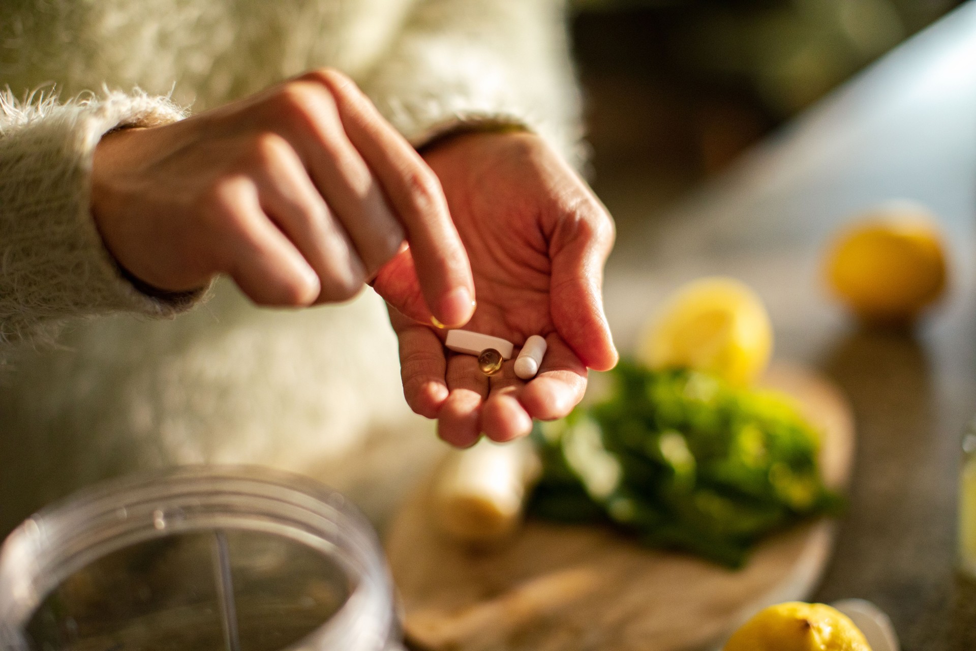 Young woman taking a health supplement in the kitchen
