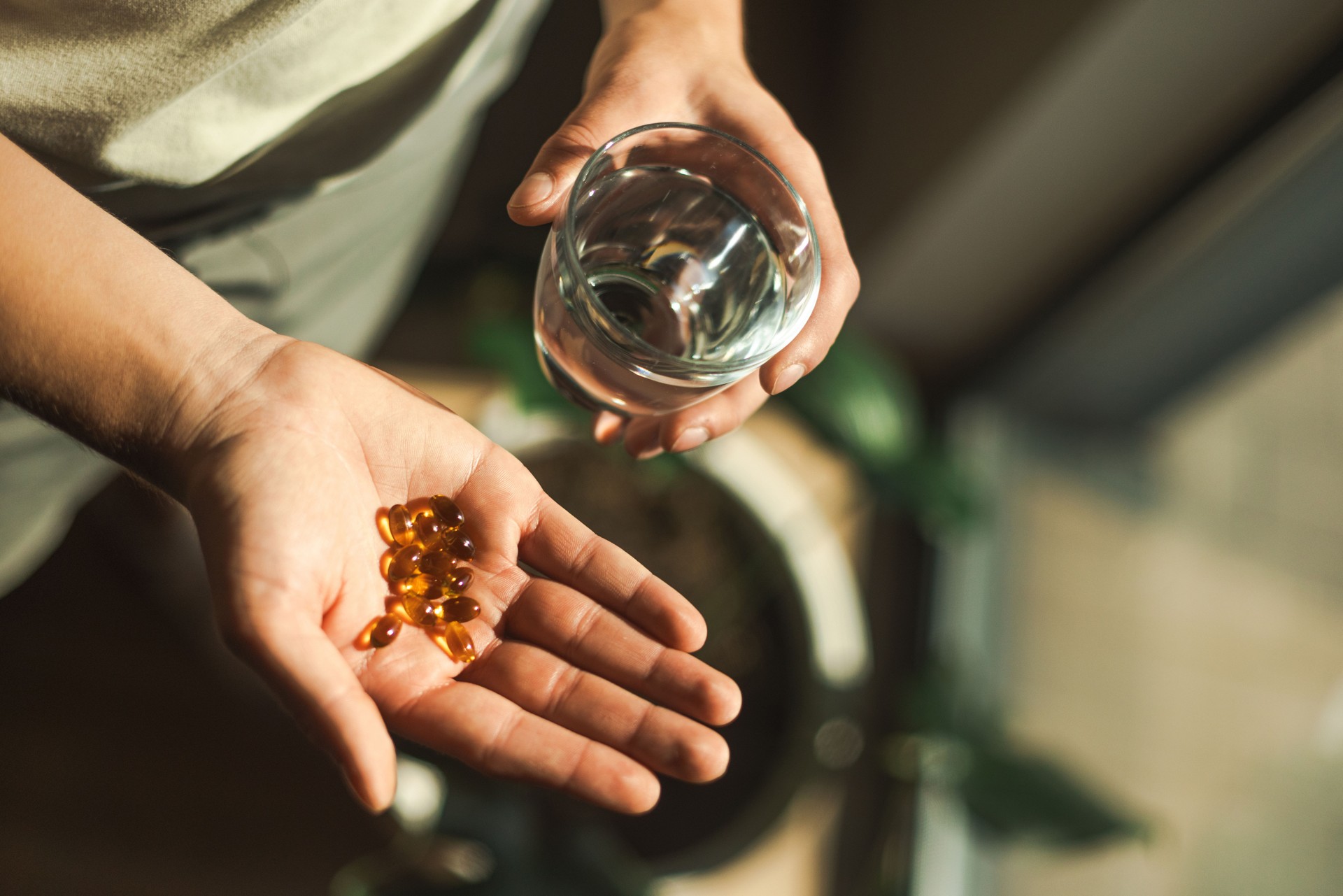 Close-Up of Hands Holding Pills and a Glass of Water